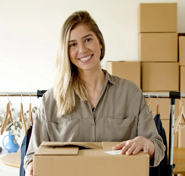 happy woman packing boxes that her business is secure and growing