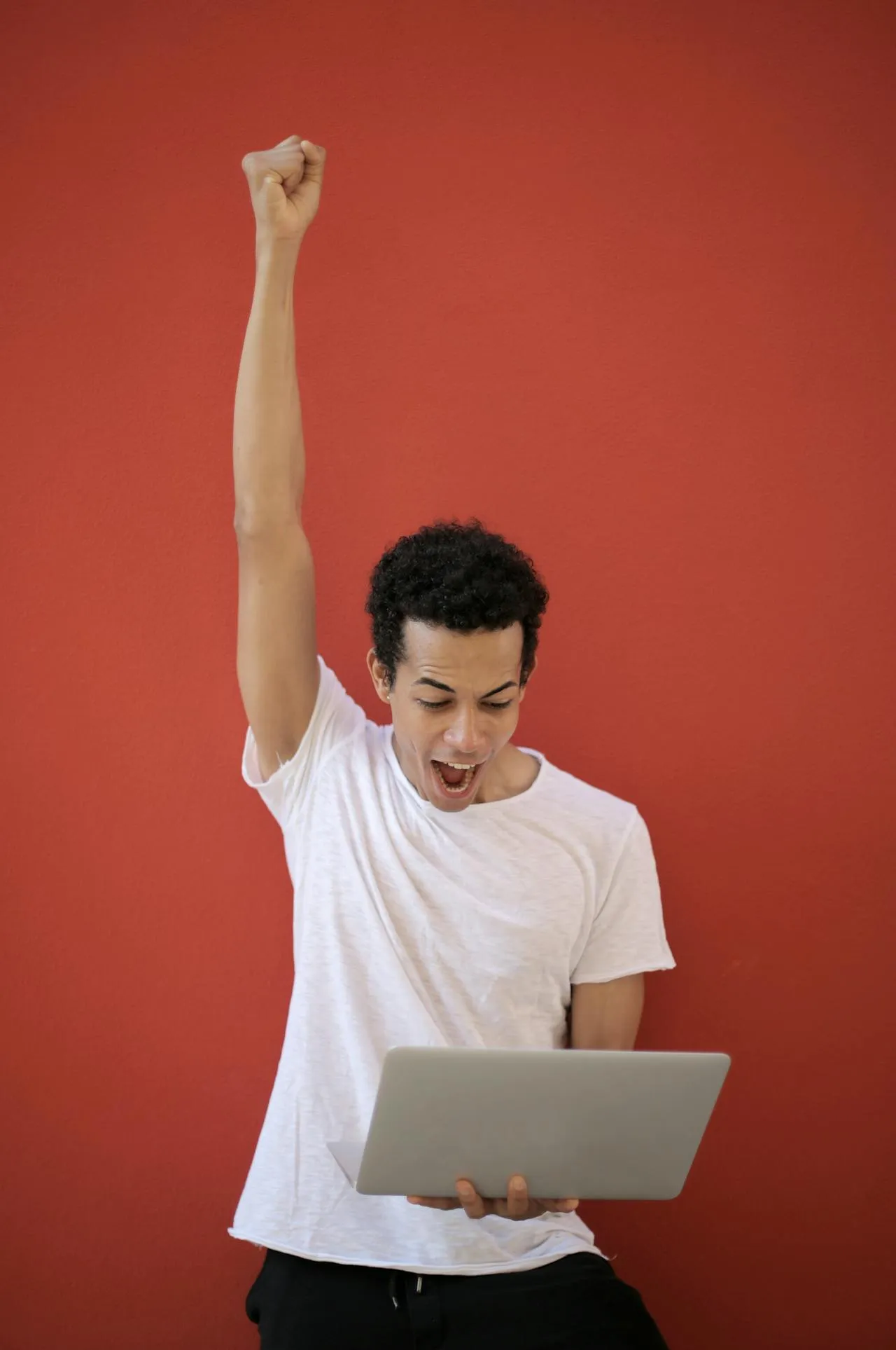 man demonstrating winning by raising one hand in victory